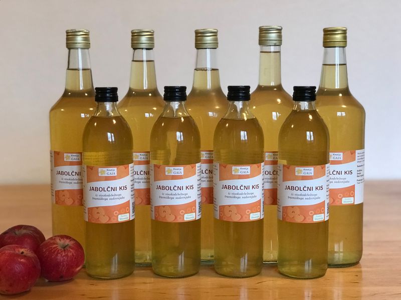 Image showing labeled bottles of apple cider vinegar with apples in the background.